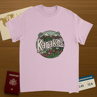 light pink Karakol Kyrgyzstan Unisex Travel T-Shirt on wooden background with world map, passport, and boarding pass